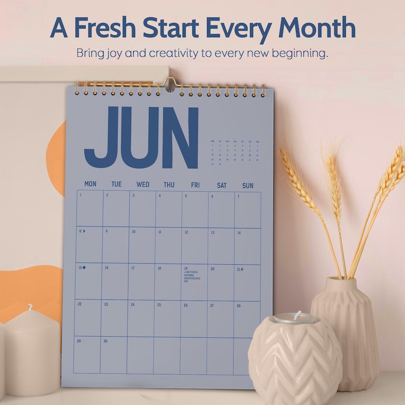 May include: A blue wall calendar for June with gold spiral binding. The calendar has a simple grid layout with the days of the week across the top. The text "A Fresh Start Every Month" and "Bring joy and creativity to every new beginning" are at the top.