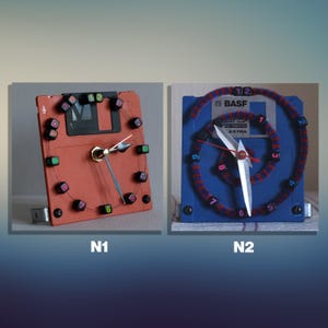 Puede incluir: Dos relojes hechos a mano con disquetes reciclados. Uno es rojo con marcadores de números negros y verdes, el otro es azul con una espiral roja y azul y manecillas blancas.