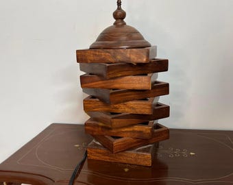 Lámpara de mesa de madera artesanal: iluminación rústica y cálida para la noche.