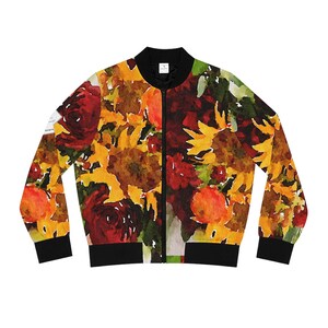Peut inclure: Veste de bombardier à motifs floraux avec un motif aquarelle de tournesols, de roses et d'autres fleurs d'automne dans les tons de jaune, de rouge et d'orange. La veste a un col, des poignets et un ourlet noirs, et une fermeture éclair intégrale.