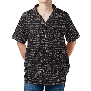 Può includere: Camicia nera a maniche corte con equazioni e simboli matematici bianchi. La camicia ha un colletto classico e una vestibilità rilassata. Realizzata in un tessuto leggero.