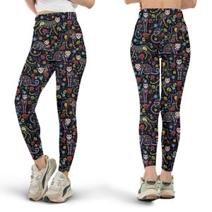 Peut inclure: Legging noir avec un motif coloré du Jour des Morts. Le legging présente un motif répété de chats squelettes, de têtes de mort et de fleurs rouges, jaunes, bleues et vertes. Le legging est moulant et en matière extensible.