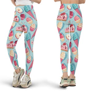 Puede incluir: Leggings azul claro con un patrón repetido de conos de helado, cupcakes, rosquillas y rebanadas de pastel. Los leggings tienen un diseño vibrante y colorido, perfecto para ropa casual. El patrón incluye elementos rosas, blancos y turquesas.