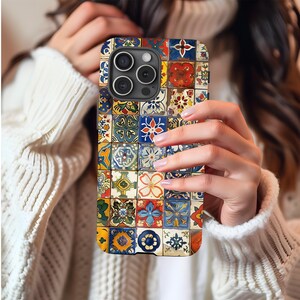 Puede incluir: Una funda de teléfono colorida con un diseño de mosaico de baldosas cuadradas en varios colores, incluyendo azul, rojo, amarillo y verde. La funda tiene un acabado brillante y un recorte para la cámara.