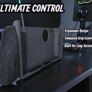 May include: A dark gray gaming controller grip with the text "ULTIMATE CONTROL." The grip features an ergonomic design and enhanced grip control. The grip is built for long gaming sessions.