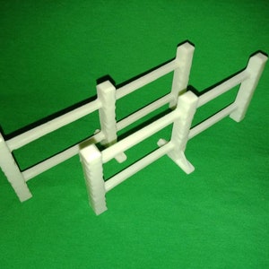 May include: Two white plastic miniature fences with three horizontal rails each. The fences are stacked on top of each other.
