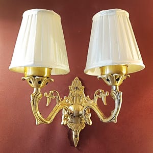 Aplique de latón antiguo de dos brazos con pantallas plisadas clásicas: elegante lámpara de pared para sala de estar.