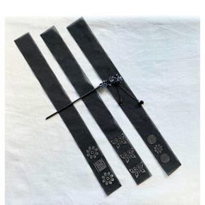 May include: Three black hair sticks with decorative floral and butterfly patterns. One stick features a floral design with Chinese characters. A decorative hair pin with blue flowers and a black tassel is also included.
