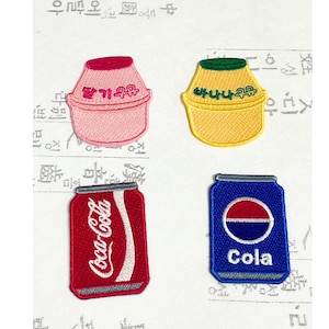以下が含まれることがあります： 食べ物と飲み物のデザインが施された4つの刺繍パッチ。ピンクのイチゴミルクカートン、黄色のバナナミルクカートン、赤いコカ・コーラ缶、青いコーラ缶が含まれています。各パッチには詳細なステッチとテキストがあります。