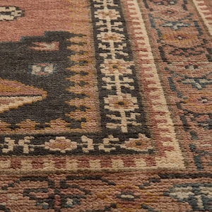 Pode incluir: Uma caneca de cerâmica branca com uma alça preta e o texto "But First, Coffee" em preto, com uma fonte manuscrita. A caneca está sobre uma superfície branca.