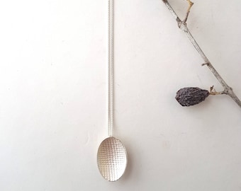 Oval pendant in silver with textured surface