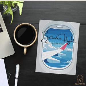 May include: A journal titled "Between Flights" with an airplane wing illustration, a cup of coffee, a laptop, and a pen on a dark surface. The journal has the text "My Layover Life Journal".