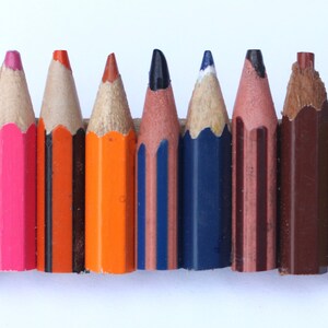 May include: A set of ten colored pencils, including orange, pink, red, brown, blue, yellow, and black. The pencils are sharpened and ready to use.
