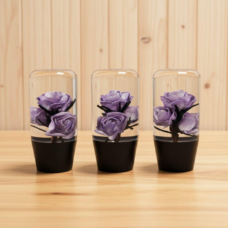 Set of three purple roses resin shift knobs standing in a row on a wooden surface, matching flower shift knob design with clear resin and violet roses inside, stylish manual shift knob for gear shifter, universal JDM inspired gear shift knob for project cars, hot rods, stance builds and sim racing rigs.