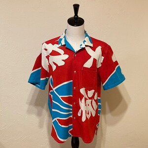 May include: A red, blue, and white short-sleeved button-down shirt with a Japanese-inspired print.