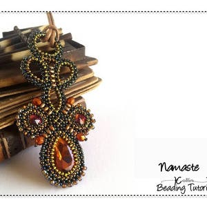 Puede incluir: Un colgante de cuentas con un diseño en forma de lágrima, que presenta una mezcla de cuentas negras, doradas y naranjas. El colgante está colgado de un cordón de cuero marrón. El texto "Namaste" y "Beading Tutorial" es visible en la imagen.