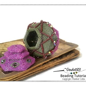 May include: A close-up of a beaded sphere with a geometric design in shades of green, red, and purple. The sphere is open and reveals a black interior. A smaller, purple beaded sphere sits on a stack of old books. The image includes the text "Studio183 Beading Tutorial Copyright Heather Collin".
