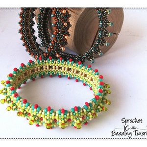 May include: Three beaded bracelets in different colours and patterns. The bracelets are made with small beads in shades of green, brown, red, and yellow. The bracelets are stacked on a wooden surface. The text "Sprocket Collin Beading Tutorial" is visible in the bottom right corner of the image.