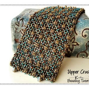 May include: A close-up of a beaded bracelet with a geometric pattern in shades of brown and teal. The bracelet is on a blue and white patterned surface. The text "Upper Crust Collin Beading Tutorial" is visible in the lower right corner of the image.