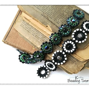 May include: A black and green beaded necklace with a geometric design. The necklace is made of small, round beads that are arranged in a pattern of circles and squares. The necklace is lying on top of a stack of old books.