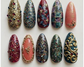 Uñas postizas vintage barrocas con filigrana dorada y diseño floral de vidrieras en color burdeos y esmeralda con gemas en 3D.
