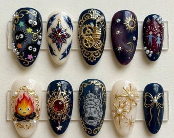May include: A set of ten almond-shaped press-on nails with various designs. The designs include stars, gears, a sun and moon, a bow, and characters from animated films, all with gold accents and pearl embellishments.
