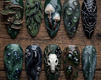 May include: A set of ten almond-shaped press-on nails featuring dark, nature-inspired 3D designs. Elements include sculpted mushrooms, mossy branches, a spider web with a spider, a white animal skull, a black slug, and raised water droplets.