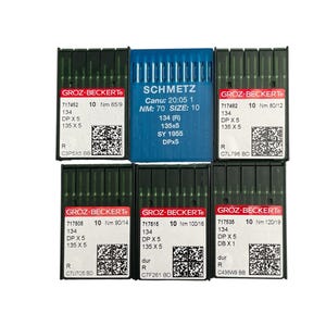 May include: A collection of sewing machine needles in green and blue packaging. The needles are from the brands GROZ-BECKERT and SCHMETZ. Each package displays product information, including size and type, with a white background.
