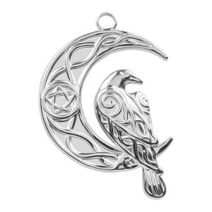 May include: A silver-toned metal pendant featuring a crescent moon shape with intricate Celtic knotwork patterns, a small five-pointed star inside a circle, and a detailed raven perched on the lower curve, complete with a top hanging loop.