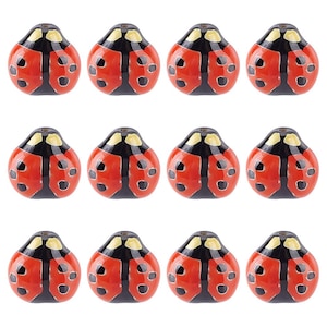 May include: Twelve ceramic ladybug figurines. Each ladybug is red with black spots and a black head. The figurines are arranged in three rows of four.