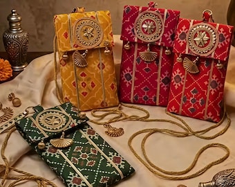 May include: Four rectangular fabric crossbody bags in yellow, dark red, bright red, and dark green. Each bag features a geometric pattern, a circular gold-toned medallion on the flap, gold-toned fan-shaped charms, and a thin gold-toned cord strap.