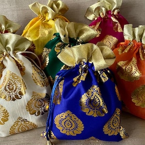 Könnte beinhalten: Eine Sammlung von Beuteln mit Kordelzug in verschiedenen Farben wie Weiß, Gelb, Grün, Blau, Orange und Magenta. Jeder Beutel verfügt über ein sich wiederholendes goldenes Blumenmuster und einen oberen Teil aus goldenem Stoff mit Kordelzug.