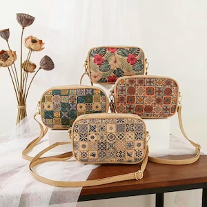 Pode incluir: Quatro bolsas transversais retangulares com alças ajustáveis. As bolsas apresentam vários padrões, incluindo desenhos florais e geométricos, em tons de castanho, verde, vermelho e azul. As bolsas são feitas de um material semelhante à cortiça.