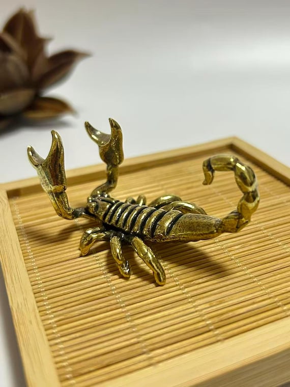 A solid brass scorpion sculpted by hand that moonlights as a pen holder — equal parts menacing desk art and actually useful.