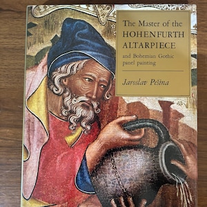 May include: A book cover featuring a detailed painting of a man with a beard and a blue hat, holding a dark jug with water pouring out. The title reads "The Master of the HOHENFURTH ALTARPIECE" with the author's name below.