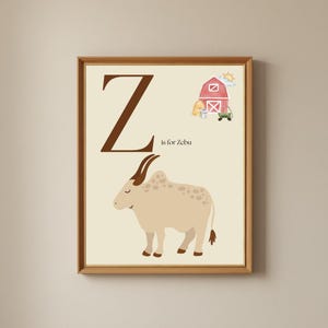 Puede incluir: Impresión enmarcada con la letra "Z" en marrón y el texto "is for Zebu". La imagen incluye un cebú beige con manchas y cuernos marrones, un granero rojo y un carro verde. El fondo es de color beige claro, ideal para un cuarto infantil.