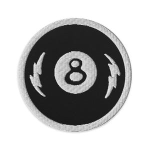 May include: A black and white embroidered patch with a white 8-ball and lightning bolts on either side.