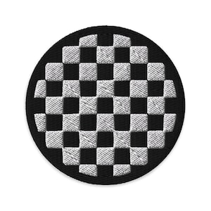 Puede incluir: Un parche bordado redondo en blanco y negro con un patrón de tablero de ajedrez clásico. El parche tiene un borde negro y un diseño detallado y texturizado. Los cuadrados del tablero de ajedrez se alternan en blanco y negro.