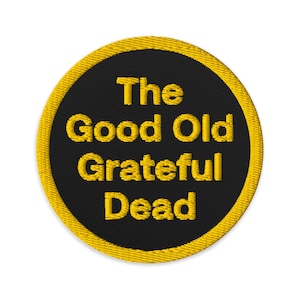 Puede incluir: Un parche redondo negro con un borde amarillo. El texto "The Good Old Grateful Dead" está bordado en amarillo.