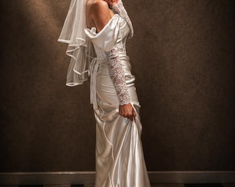 Vestido de novia de satén blanco roto, moderno, ajustado, sin tirantes, con cordones y escote Bardot. Incluye guantes y velo.