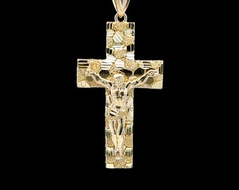 Op de afbeelding: Een gouden hangerketting met een gedetailleerd kruisbeeld. Het kruis heeft een getextureerd oppervlak en toont Jezus Christus. De hanger hangt aan een fijne gouden ketting tegen een zwarte achtergrond.