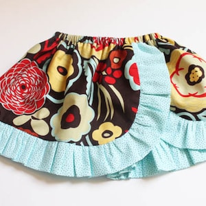 May include: A brown and blue skirt with a floral print and a ruffled hem. The skirt has a blue and white polka dot lining.