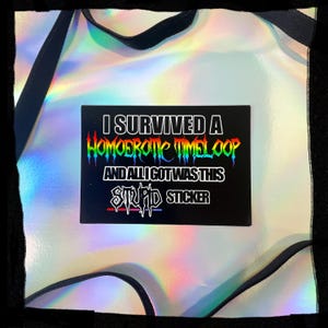 May include: A black sticker with the text "I SURVIVED A HOMOEROTIC TIMELOOP AND ALL I GOT WAS THIS STUPID STICKER" in rainbow and white lettering. The sticker is on a holographic, iridescent background.