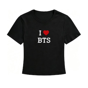 May include: A black short-sleeved t-shirt featuring a graphic on the chest. The graphic consists of the letter I in white, a red heart symbol, and the letters BTS in white text positioned directly below the heart and the letter I.