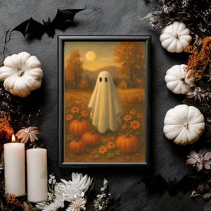 Könnte beinhalten: Ein gerahmter Halloween-Druck mit einem Geist in einem Feld aus Kürbissen und Blumen unter einem Vollmond. Das Kunstwerk ist von weißen Kürbissen, Kerzen und schwarzen Fledermausdekorationen umgeben, was eine festliche Herbstausstellung schafft.