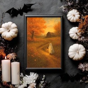 Könnte beinhalten: Gerahmtes Herbstlandschaftsbild mit einem Geist, der eine Laterne auf einem Weg zu einer Scheune trägt. Das Gemälde ist von weißen Kürbissen, Kerzen und schwarzen Fledermausdekorationen umgeben, was ein Halloween-Thema ergibt.