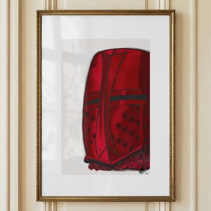 May include: Framed artwork featuring a vibrant red helmet with black accents and a decorative fringe. The artwork is displayed in a gold-colored frame, adding a touch of elegance. The image is mounted on a white background.