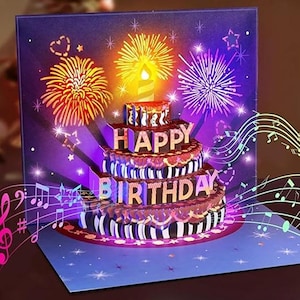 May include: A pop-up birthday card with a three-tiered cake, gold 'HAPPY BIRTHDAY' lettering, and a purple backdrop. The design includes fireworks and musical notes.