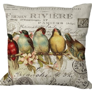 May include: Square throw pillow with a vintage design featuring five colorful birds perched on a branch with blossoms. The background has faded text and stamps, with the text "FIRMIN RIVIERE" visible.