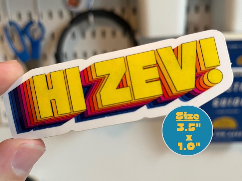 Może przedstawiać: Prostokątna naklejka z ż&oacute;łtym napisem "HI ZEV!" obramowanym tęczowym gradientem. Naklejka ma wymiary 8,9 cm na 2,5 cm. Naklejka ma efekt 3D z białym obramowaniem.